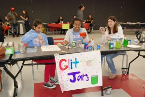 Shaking up glitter jars, junior Bethlehem Yigzaw and sophomore Cecilia Glennie participate in events at this year’s festival, which also included activities such as spin art, portrait drawing and face painting.
