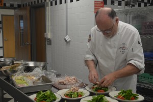 Chef Ciaran Devlin prepares a spinach salad in the class kitchen for Marshall’s Five Star Cafe. In the Five Star Cafe, the food is hand prepared and costs $8 per meal.