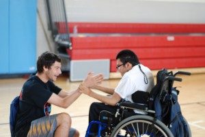 Senior John Michael Gatti works with junior Mohammed Al Dosari during gym class in the main gym during third block. The class particpated in activities such as basketball. 