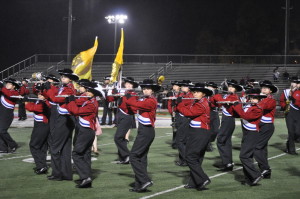 The marching band performs during the Nov. 6 varsity football game against Thomas Jefferson High School for Science and Technology. The band performed its show in spite of the pouring rain and unideal weather conditions during what very well could have been its final halftime appearance of the year. 