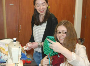 Senior Sarah Boyle looks on as sophomore Courtney Johnson works on a costume for She Kills Monsters, the upcoming one-act for the Virginia High School League theater competition.