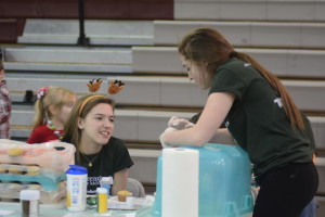 Juniors Gillian McIntyre and Shannon Russell run a cupcake decorating booth. 