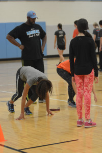 Coach Clifford Wong helps a group of freshman sprinters practice their starts during one of the track team’s practices over winter break in the auxiliary gym.
