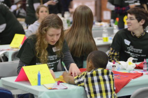 Senior Valerie Cyphers works on a shirt with one of the children at the Holiday for Hope party held at McKinley Tech High School on Dec. 19. Holiday for Hope is an annual event hosted by Octagon along with the Dreams for Kids organization. 