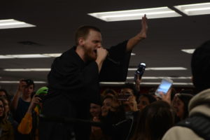 Matthew Horne sings with a crowd of enthusiastic students. "We want to perform if more students are getting inspired by the Toast ghost aesthetic,"" Horne said. "We don't just want to sing our songs, but to have students making the music with us and without us and to be having a good time."