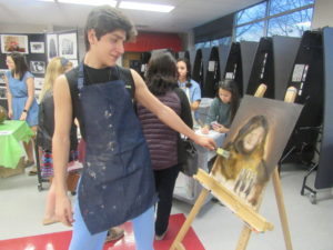 Junior Reza Mirzaiee paints at the Freshmen Orientation in order to promote the GCM art department. “I was projecting a medieval rendition of my IB English teacher, Mr. Macindoe onto the canvas,” Mirzaiee said.
