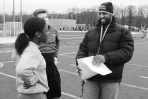 Track and Field head Clifford Wong conferences with track athletes and seniors Thando Muchmenyi and Colin Niniger at practice on March 6.