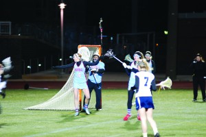 Pointing behind the goal, sophomore Emily Reinhart  directs the defense in varsity lacrosse’s first game of the season as sophomore goalie Ellie Mandell watches.  The team defeated Washington & Lee High School 10-8.