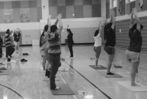 Gathering in the main gym during Wellness Week, a large group of student participants follows a leader in yoga exercises. Physical and mental activities were open to all during Learn and all three lunches. Courtesy of Gina Fajardo.