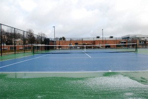 Seen from behind the school, the new tennis courts glisten on a recent snowy day. Tennis team members and coaches are excited for the home practices the new courts allow.