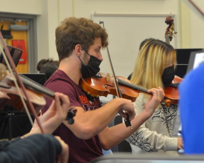 Henry Smith plays the violin at a Marshall choir concert