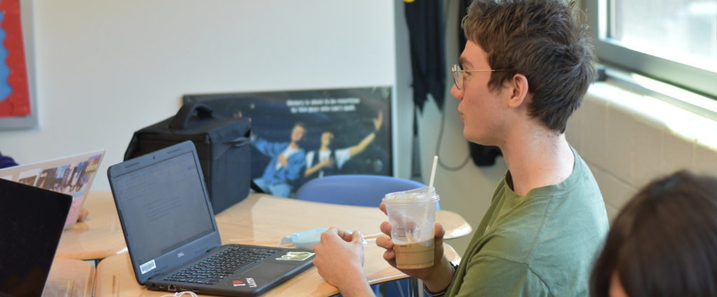 Junior Sam Peden drinks coffee and prepares for an exam in English teacher Matthew Horne’s class during Learn.